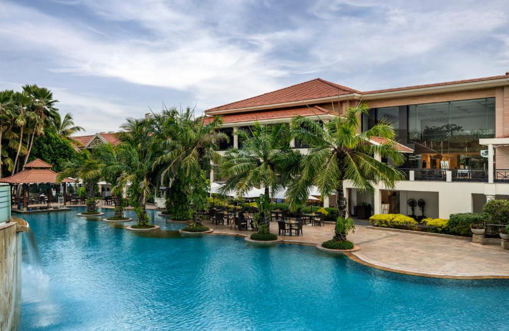 ein Swimmingpool vor einem Ferienresort in der Unterkunft Palm Meadows Resort in Bangalore