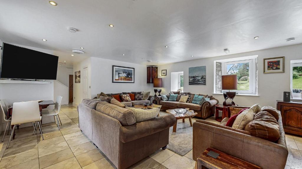 ein Wohnzimmer mit Sofas und einem Flachbildfernseher in der Unterkunft Finest Retreats - Old Barn at Ormidale House in Clachan of Glendaruel