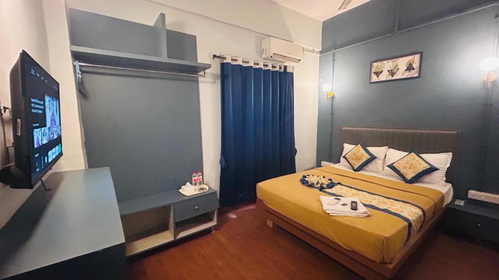 a bedroom with a bed and a television in a room at Hotel Cozy Inn in Kālundri