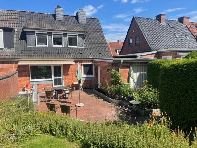 a backyard of a house with a table and chairs at Möwennest in Timmendorfer Strand