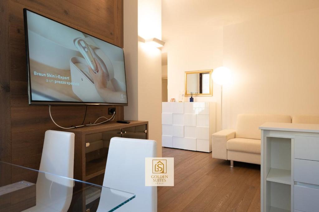 een woonkamer met een flatscreen-tv aan de muur bij GoldenSuitesItaly Piazza Duomo Luxury Apartment 3 in Trento