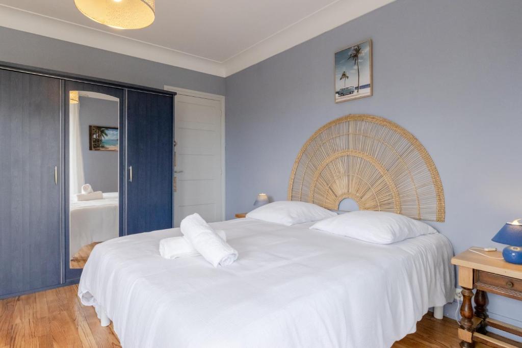 una camera da letto con un letto grande con lenzuola bianche di Villa Amistad - Chambre Tilleul - centre - parking - jardin - logement partagé - a Mont-de-Marsan
