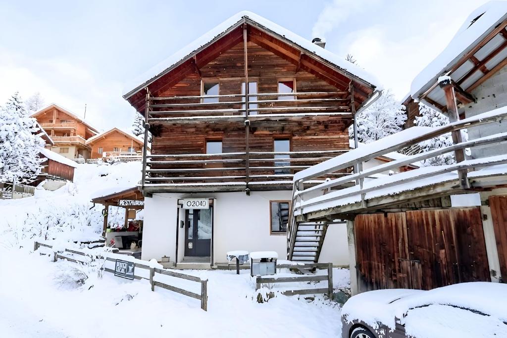 a log cabin in the snow with a garage at Casa 2040 Family-Friendly Chalet Saint-Véran in Saint-Véran