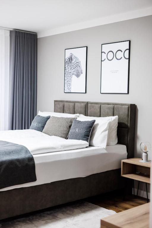 a bedroom with a large bed with two pictures on the wall at Kurpark Suites in Bad Salzuflen