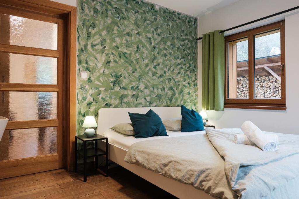 a bedroom with a bed with blue pillows on it at Apartmány Kamenice "Kamčatka" in Březová