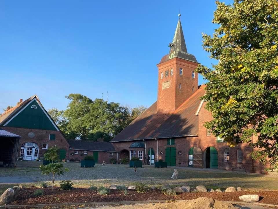 a large red brick building with a clock tower at Gut Ellernwurth in Wurster Nordseeküste