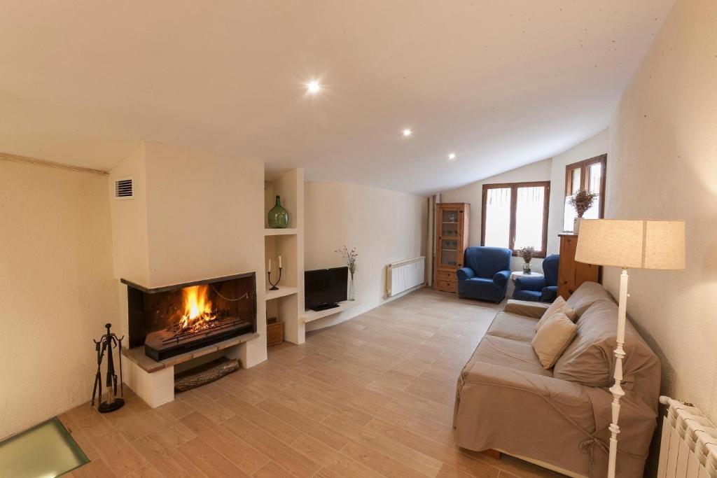 ein Wohnzimmer mit Couch und Kamin in der Unterkunft Cal Marti in Farena