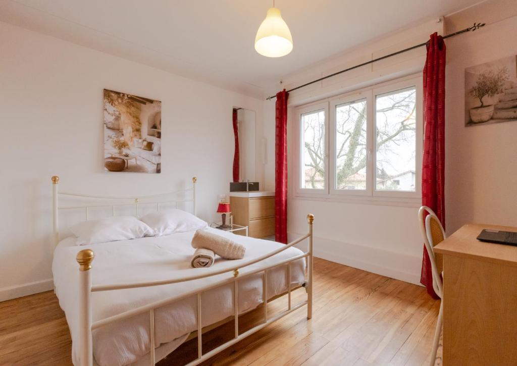 A bed or beds in a room at Villa Amistad- Chambre Olivier - centre - parking - jardin - logement partagé