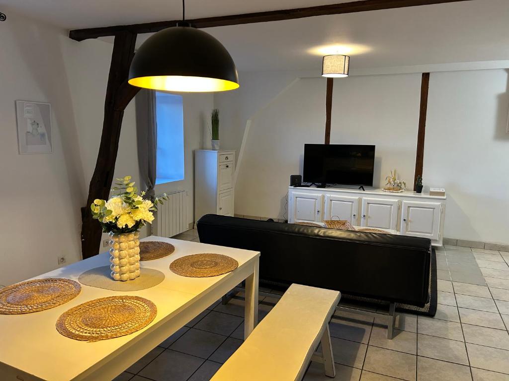 ein Wohnzimmer mit Tisch und Fernseher in der Unterkunft Appartement 80m2 3 chambres 5 lits in Vierzon