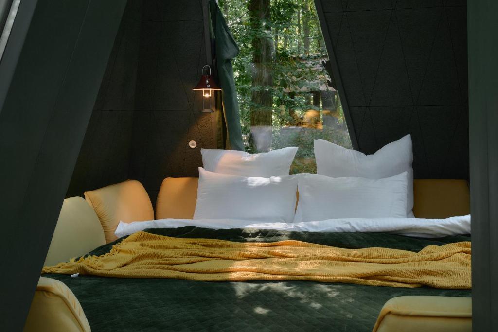 ein großes Bett mit weißen Kissen und einem Fenster in der Unterkunft Namety Park in Kiew