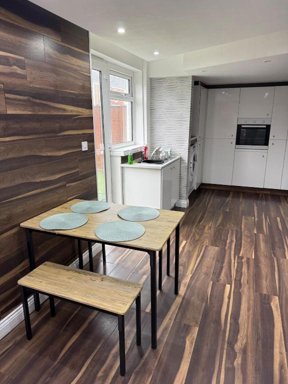 a kitchen with two wooden tables and a kitchen with white appliances at 4Bed Grimsby Contractor Work Crew Stay in Grimsby