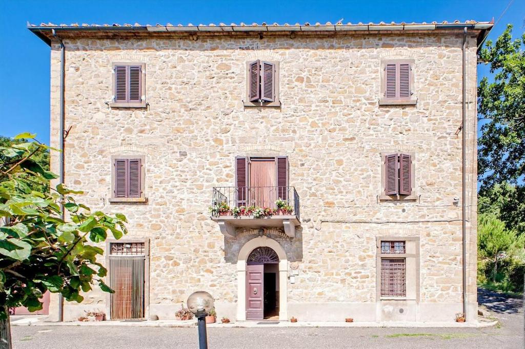 I Castagnini في بمونتيكاتيني فال دي سيسينا: مبنى حجري كبير مع شرفة عليه