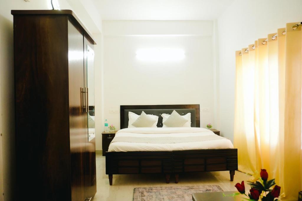 a bedroom with a large bed with white sheets at Dhananjay home stay in Dharampur