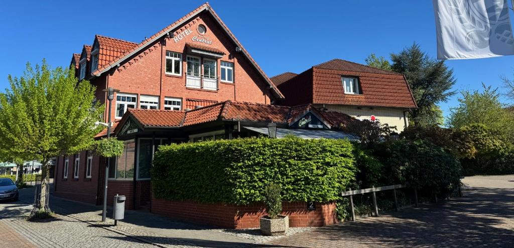 a brick house with a hedge in front of it at Hotel Central in Zeven