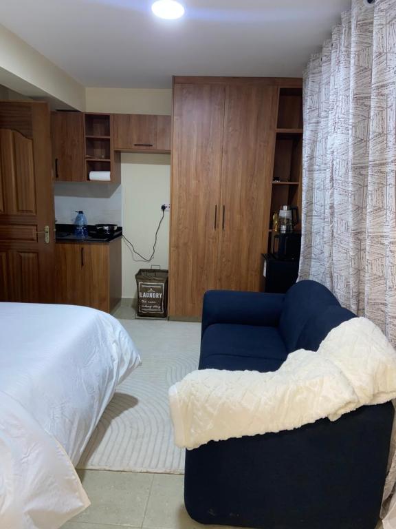 Un dormitorio con una cama y una silla azul. en Terus studio, en Nanyuki