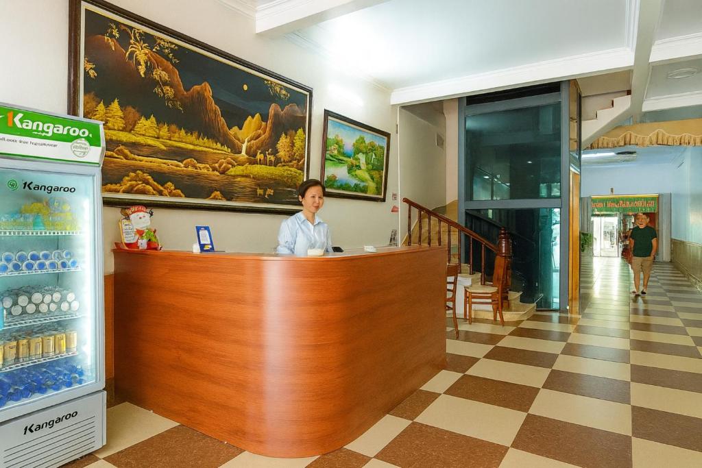 Ein Mann, der an einem Tresen in der Lobby sitzt. in der Unterkunft Hà Thành Motel Bắc Ninh in Bắc Ninh