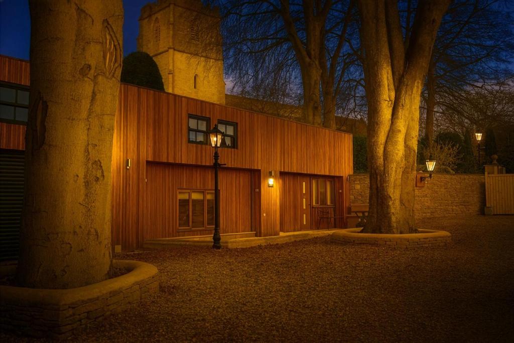 a building with a street light next to two trees at Barn Cottage Painswick in Painswick