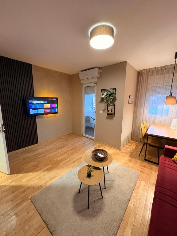 Una sala de estar con un sofá rojo y una mesa. en NAR Royalton Apartment #01, en Niš