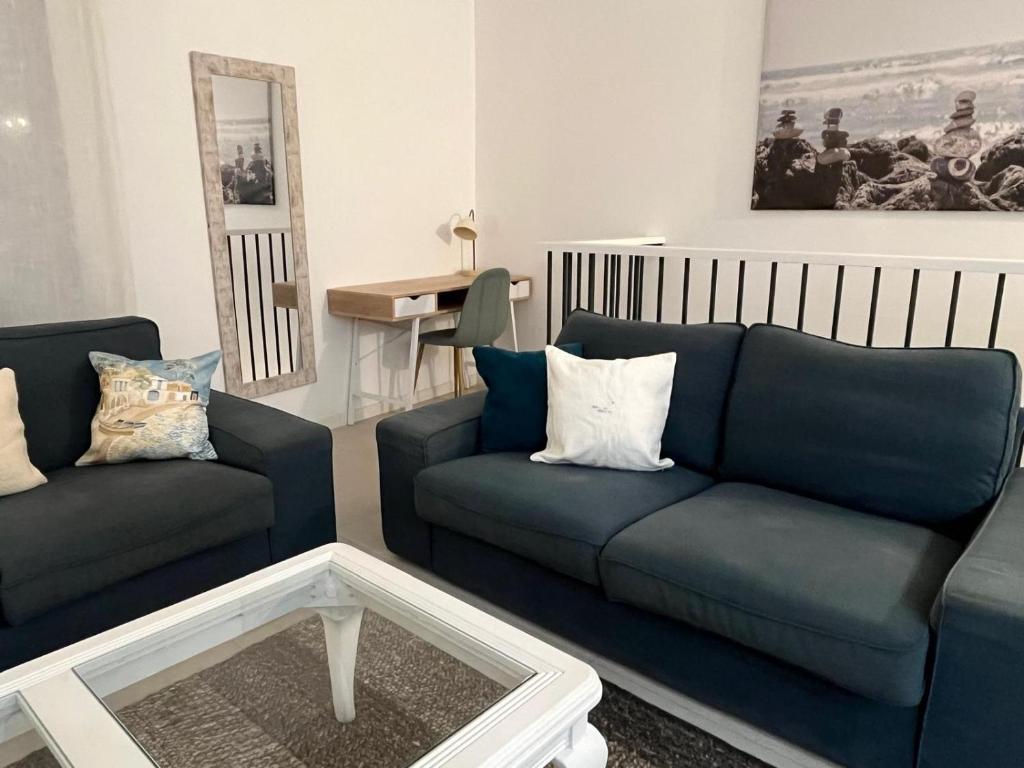 a living room with two blue couches and a table at Piso en el Centro de La Cala in Mijas Costa