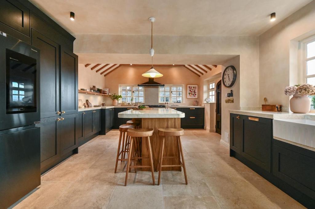 a large kitchen with black cabinets and a island at Merryweather in Canterbury