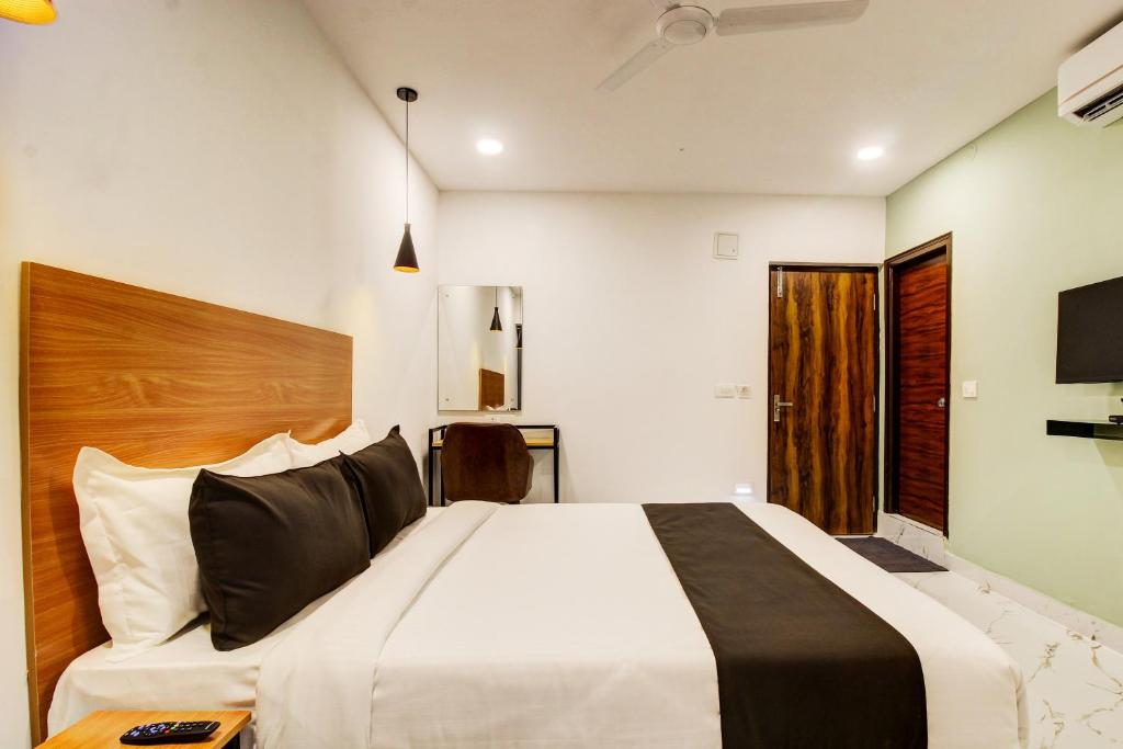a bedroom with a large bed with a wooden headboard at Super Townhouse Rcc Hotel Banjara Hills in Hyderabad