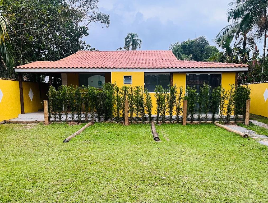 una casa gialla con una recinzione davanti di Chalés Boraceia Duda a Boracéia