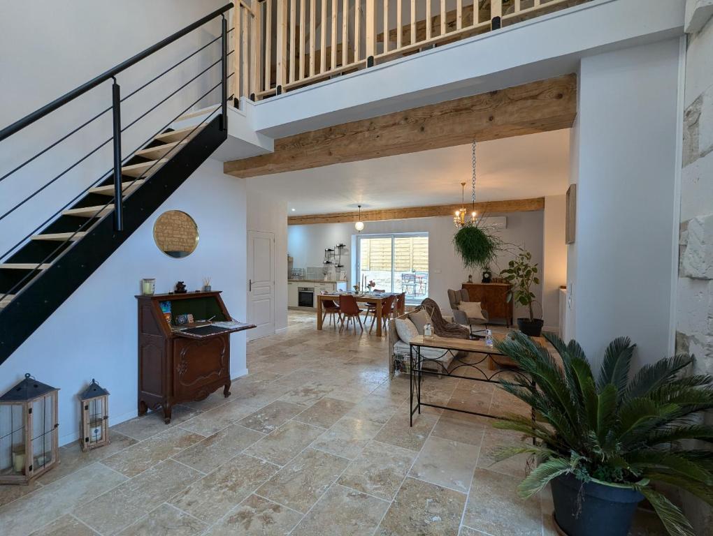 an open living room with a staircase and a dining room at Les Pierres Douces in Champniers