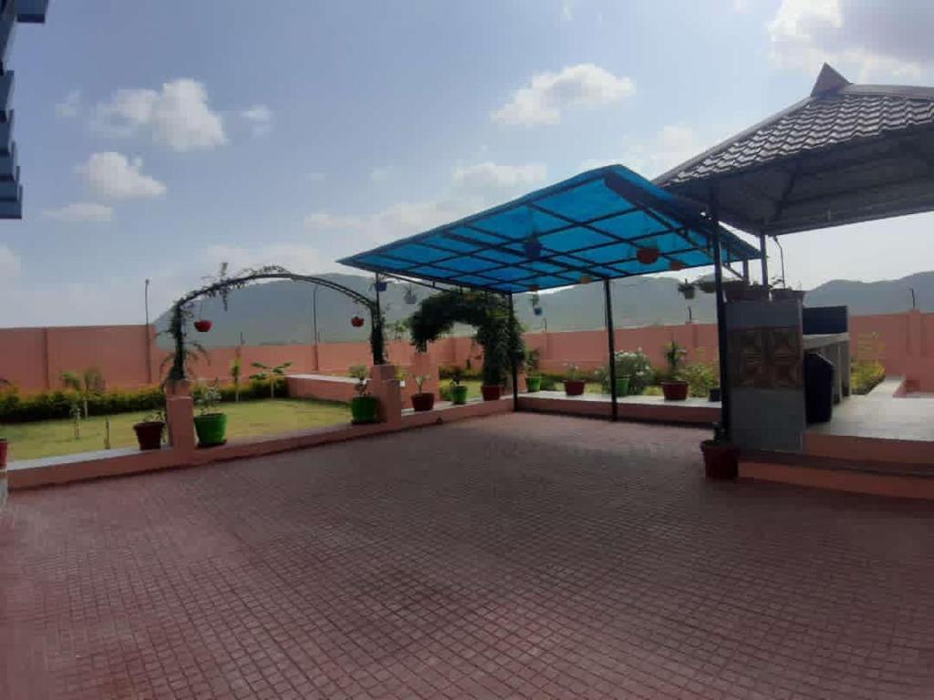 een paviljoen met een blauwe luifel in een park bij The time's stay in Nāi