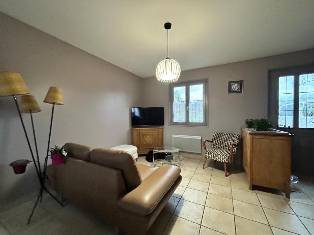 にあるAux Forts Champsのソファとテレビのあるリビングルーム