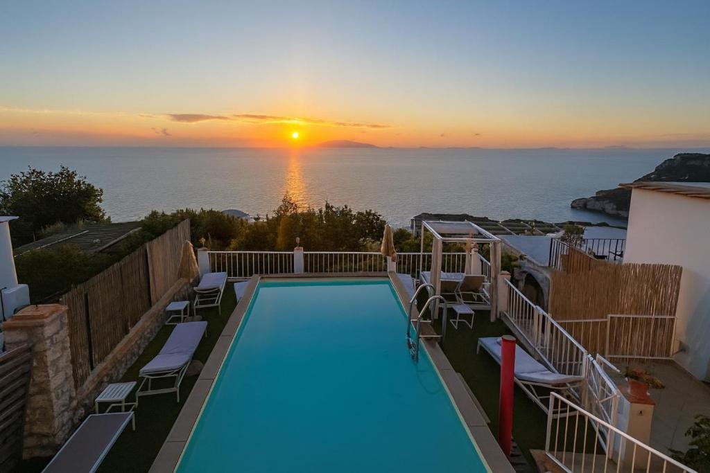 a swimming pool with a view of the ocean at sunset at B&B La Danza del Mare in Anacapri