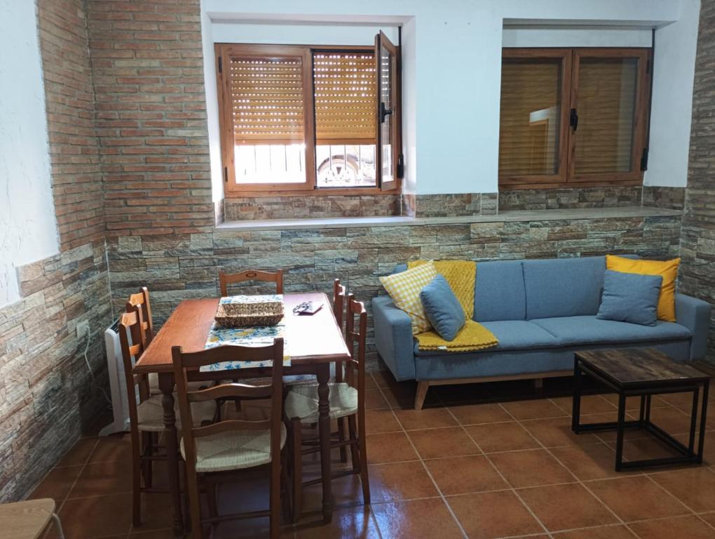 Una sala de estar con un sofá azul y una mesa. en Apt Santa Cruz de Caravaca, en Caravaca de la Cruz