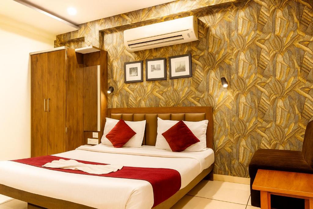 a bedroom with a bed and a wall at Hotel Shree Ram Palace in Indore