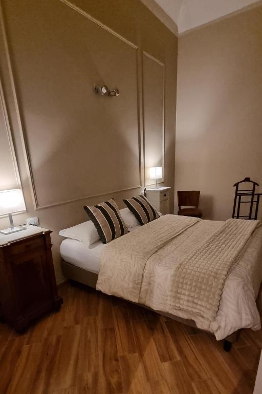 a bedroom with a large bed and a wooden floor at Dimora Largo Silvestro dell'Aquila- Centro Storico in LʼAquila