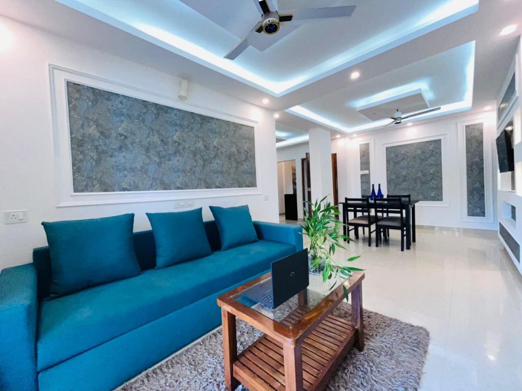 a living room with a blue couch and a table at Villa platinum 4 BHK Calangute in Calangute