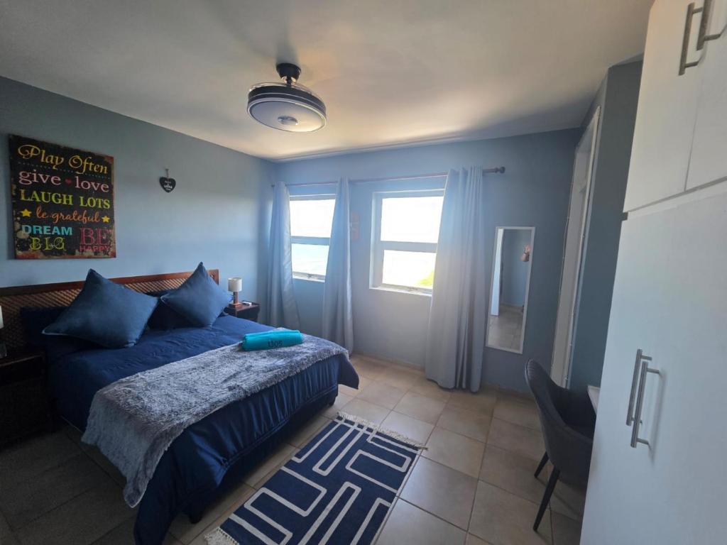 een slaapkamer met een blauw bed en een raam bij Amanzi 1305 in Vosburg