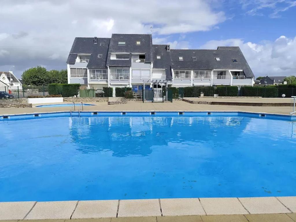 a large blue swimming pool in front of a house at Appartement cosy à Damgan avec vue mer 32 m² in Damgan