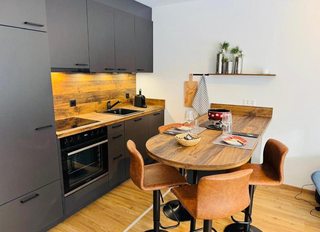 una cucina con tavolo e sedie in legno di Schickes Apartment im herzen Pontresina a Pontresina
