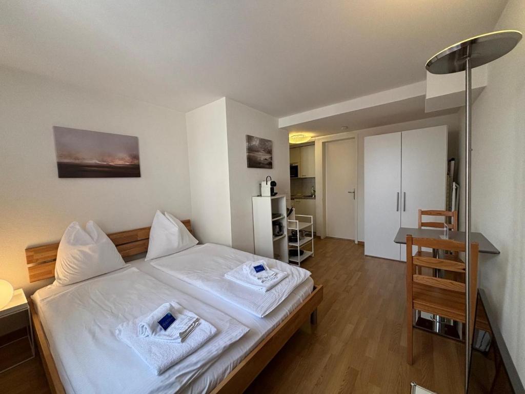 una camera da letto con letto con lenzuola bianche e scrivania di Studio at famous Storchengasse - Stork 45 a Zurigo