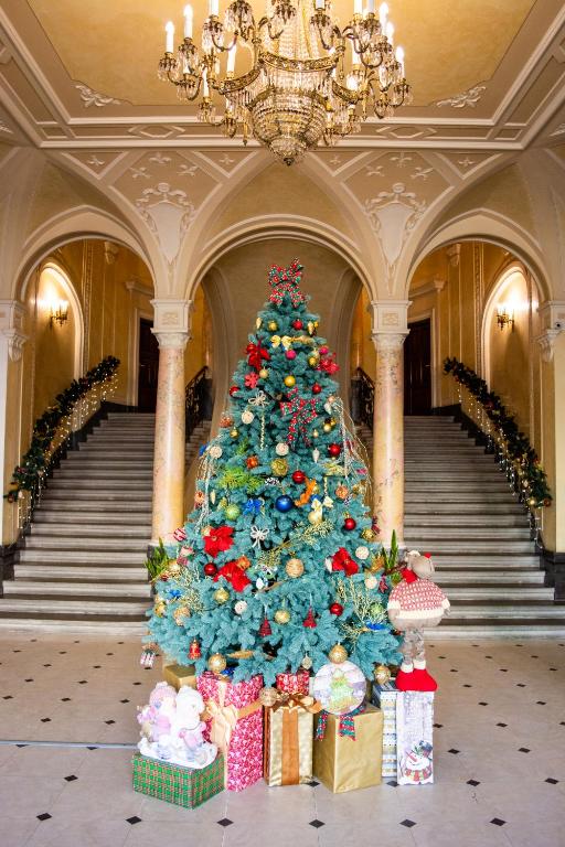 a christmas tree in a building with presents around it at George Hotel in Lviv