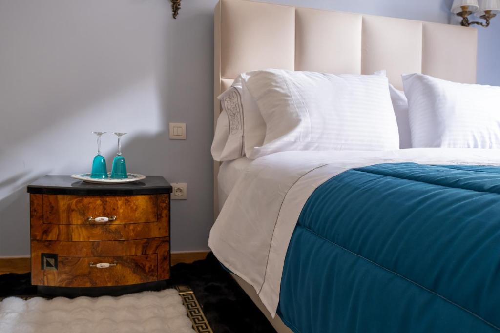 una camera da letto con letto con lenzuola blu e bianche e comodino di Theodoros Kolokotronis - Polimnia a Nauplia