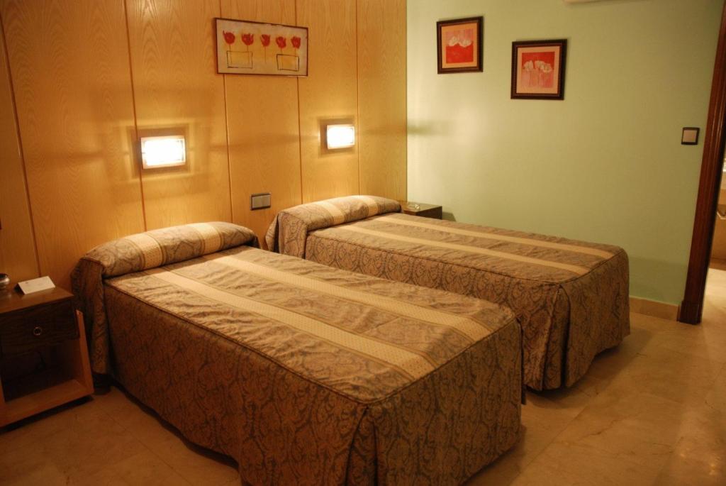 a room with two beds in a room at Hostal Los 5 Pinos in Madrid