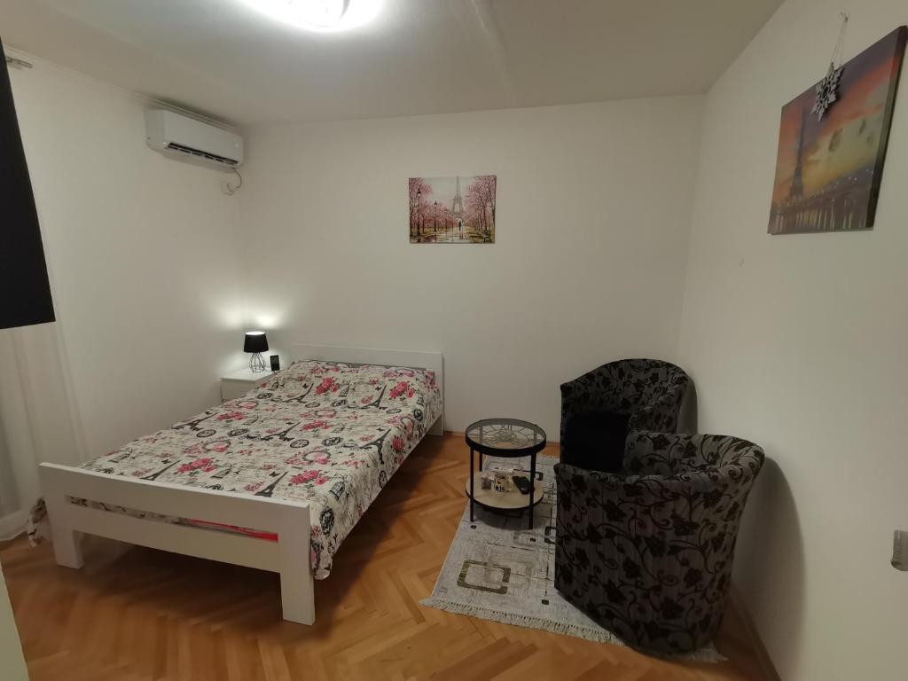 un dormitorio con una cama y una silla en Relaks, en Nikšić