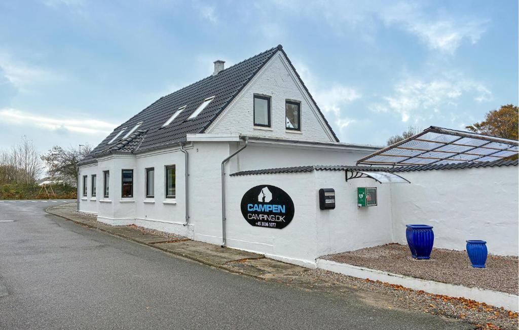 a white building with a sign on the side of it at 7 Bedroom Stunning Home In Samsø in Kolby Kås