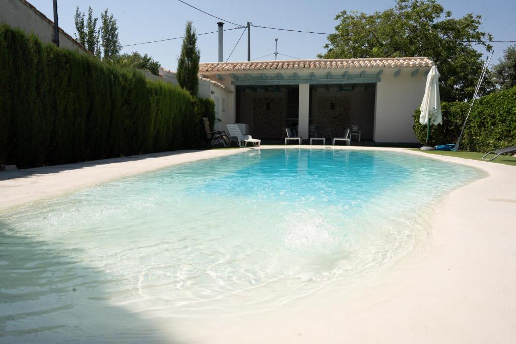 a swimming pool in front of a house at Casa Rural Álvarez in Caravaca de la Cruz