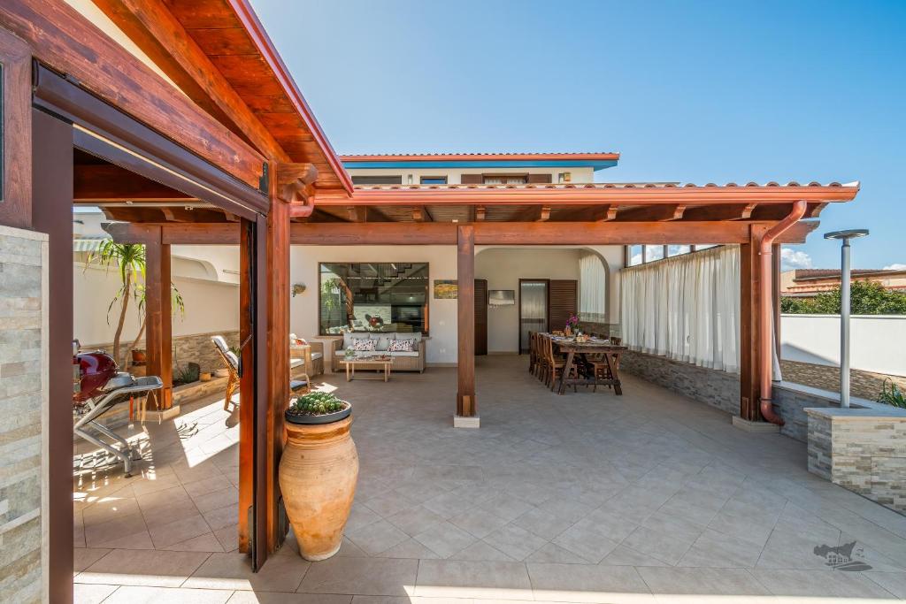 un patio extérieur avec une pergola en bois dans l'établissement Villa DellOmbra, à Alcamo