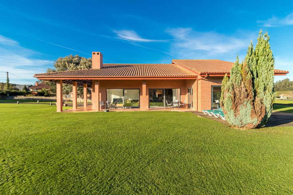 a house with a large lawn in front of it at Villa Monasterio in Escobedo