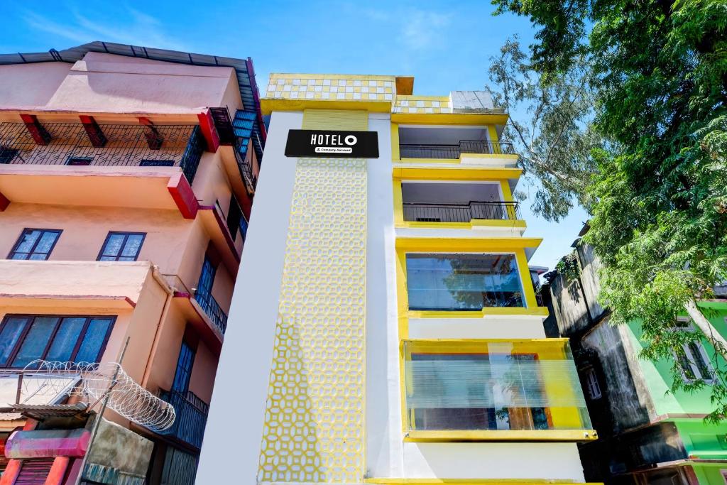 Ein hohes gelbes Gebäude mit einem Schild drauf. in der Unterkunft Hotel O Nepali Mandir Bus Terminal Formerly Hotel Aaghnya in Guwahati
