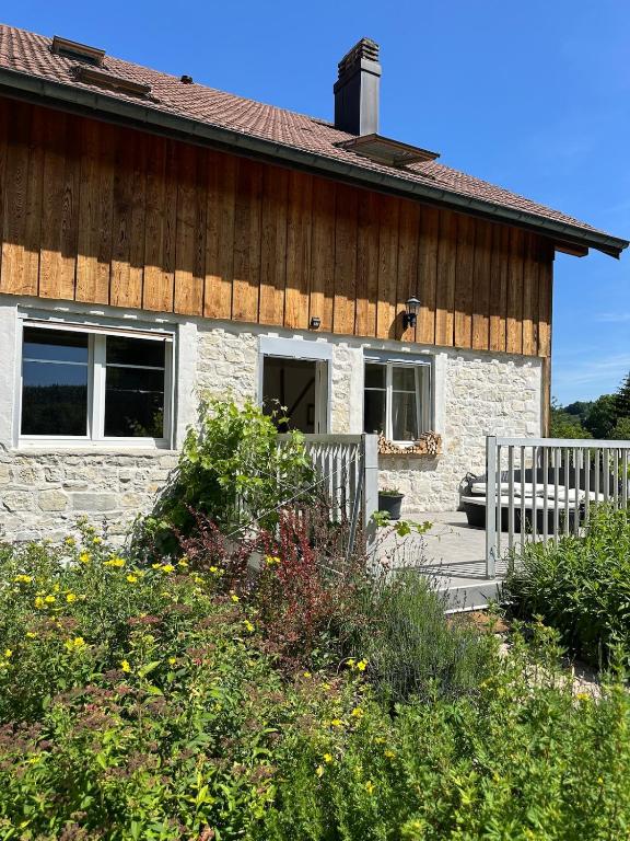 a brick house with a white fence in front of it at Gîte le Frêne in Fuans