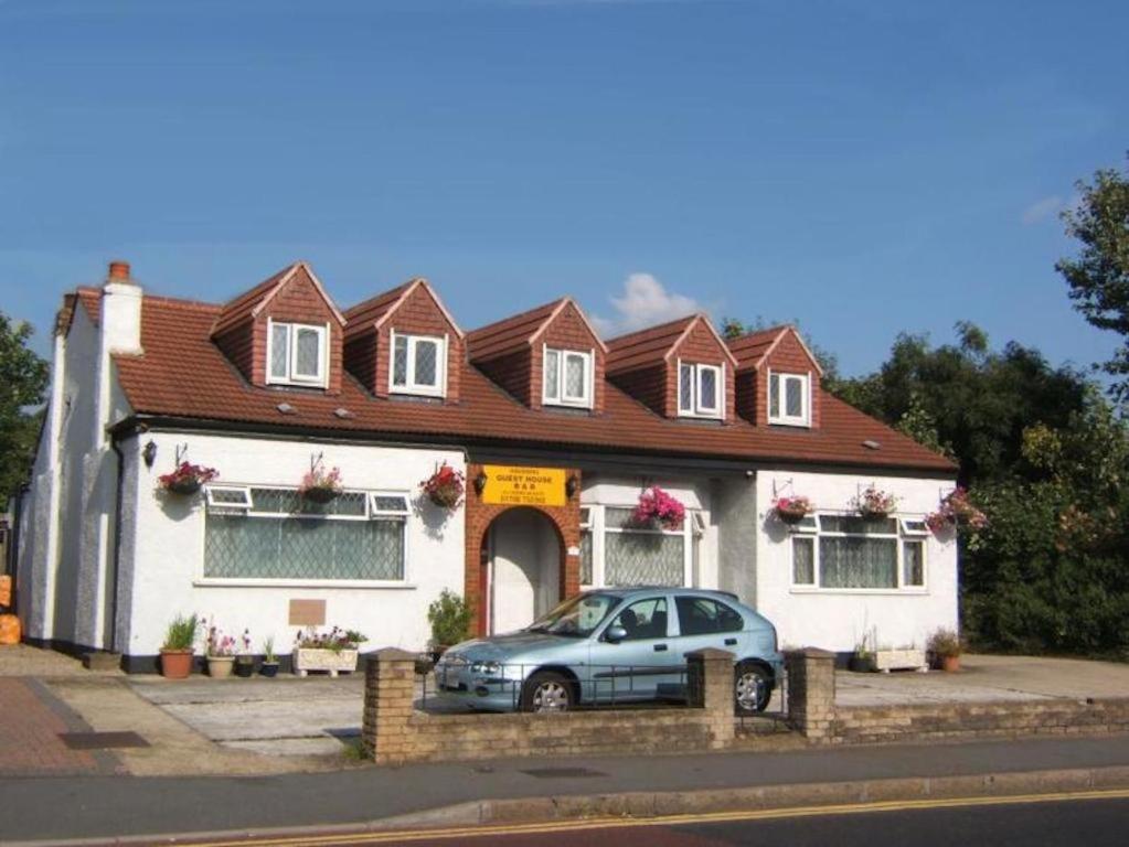 una casa con un coche aparcado delante de ella en Havering Hotel, en Romford