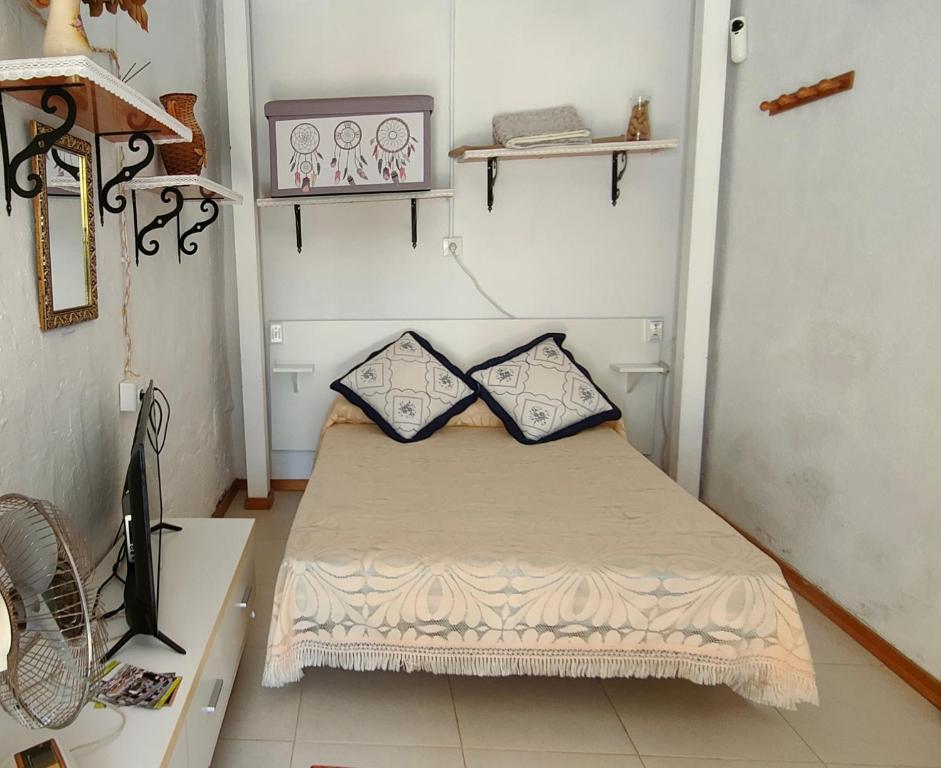 a small room with a bed with two pillows on it at La Pequeña Parrita in Guadalcanal